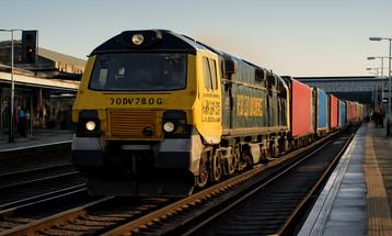 Freight Train Moving Through Bustling Train Station